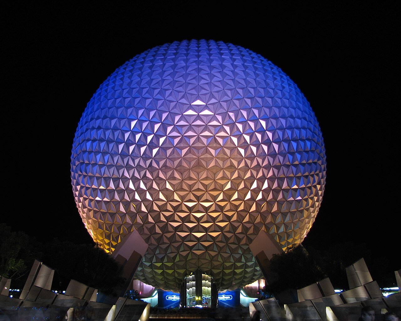 Spaceship Earth illuminated in blue and gold at EPCOT after dark