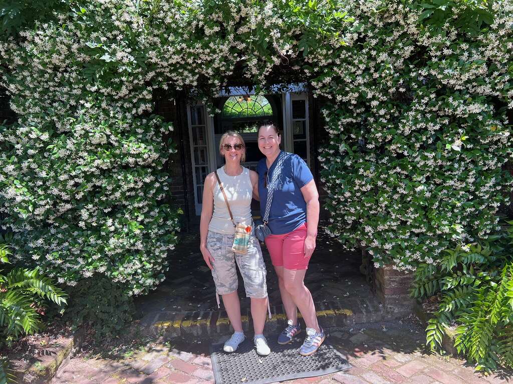 Jennifer and Heather under a flowering jasmine archway at Boone Hall Plantation on a Charleston girls' trip