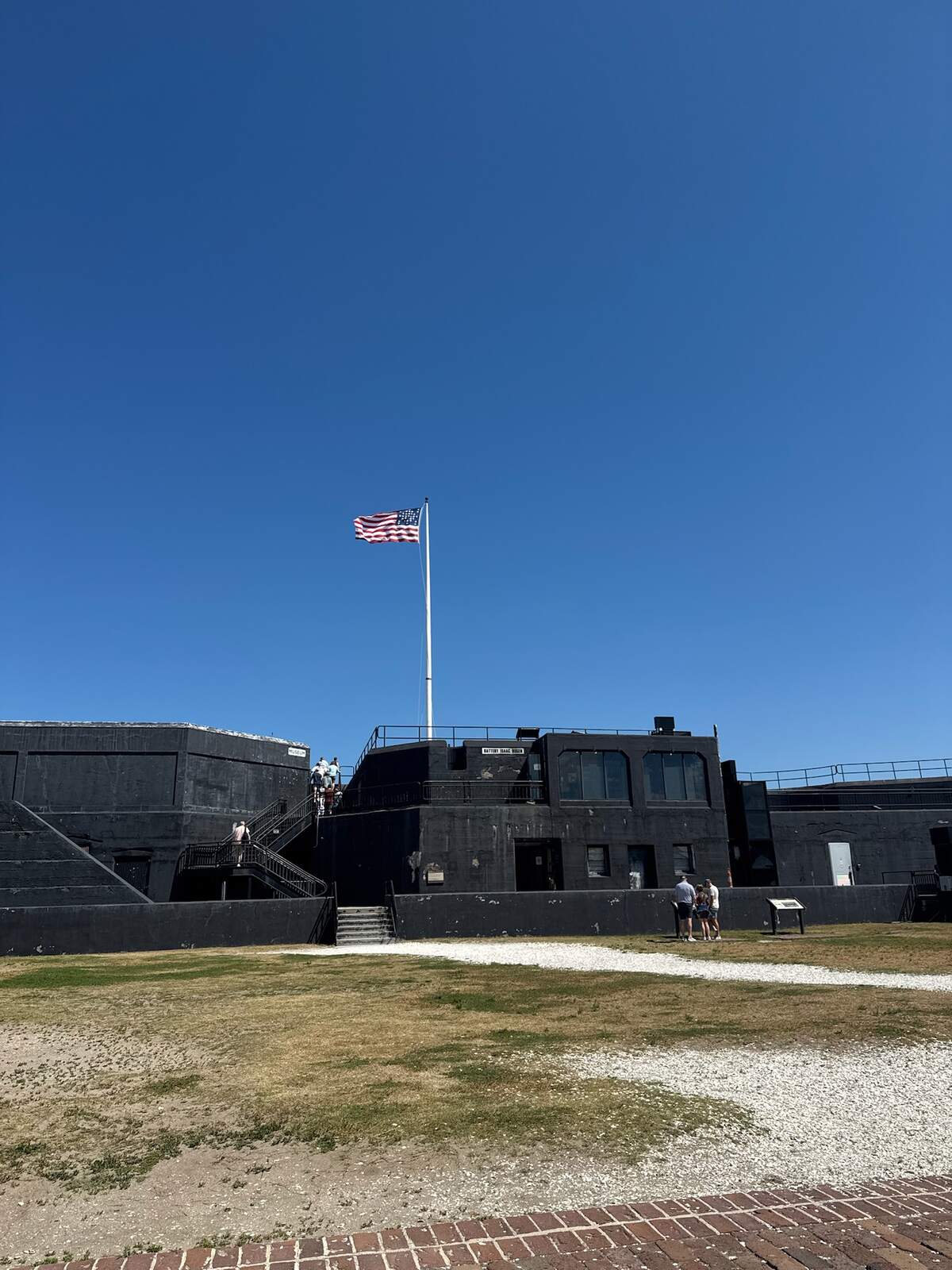 The flag flying over Battery Isaac Huger inside Fort Sumter on a Charleston girls' trip, bright blue sky over the fort